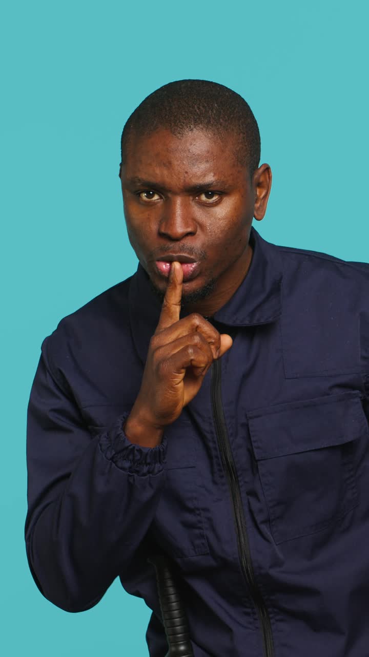 African American Man Gesturing for Silence with Finger on Lips