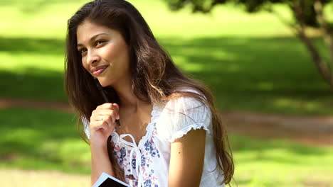 Linda-Chica-Sentada-En-El-Pasto-Estudiando