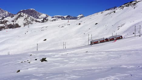 Gornergrat-mountain-railway-moving-through-the-ski-pistes-of-a-ski-resort-near-Zermatt-in-the-snow-covered-mountains-of-the-Swiss-alps,-Switzerland