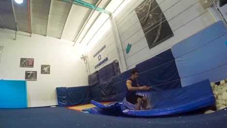 a slow motion still shot of a guy doing flips from the trampoline landing and winning having fun and working out in 60fps