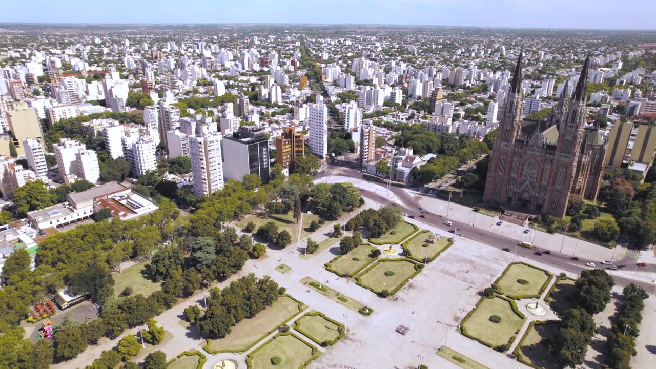 Vista aerea con drone 4K di Plaza Moreno a La Plata, Buenos Aires, Argentina. Storica piazza centrale circondata dalla Cattedrale, edifici governativi, spazi verdi e il cuore urbano della città.