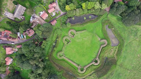 Aerial-video-footage-of-the-remains-of-Bolingbroke-Castle-a-13th-century-hexagonal-castle,-birthplace-of-the-future-King-Henry-IV,-with-adjacent-earthwork