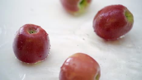 slomo de manzanas en agua sobre fondo blanco