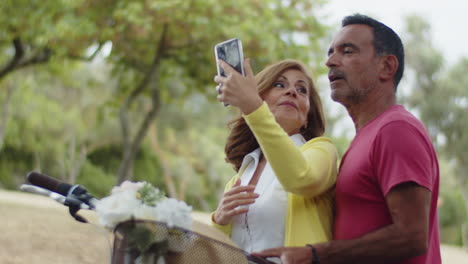 Happy-Caucasian-couple-looking-at-camera,-taking-selfie-on-phone