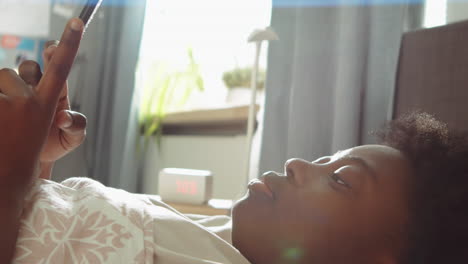 Mujer-Afroamericana-Acostada-En-La-Cama-Y-Usando-El-Teléfono