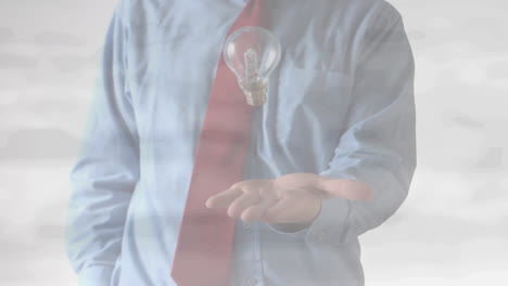 animation of midsection of businessman throwing and catching lightbulb