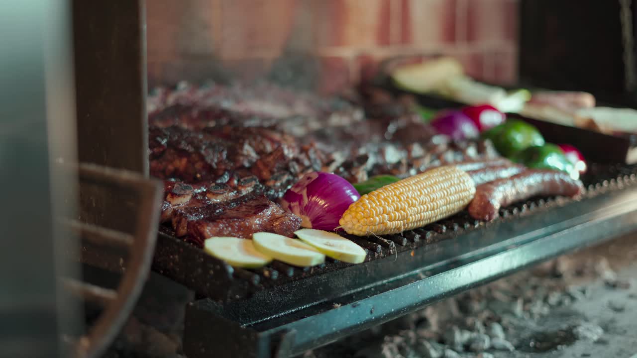 disparo móvil de una parrilla humeante llena de carne y verduras recién asadas de las que una persona se sirve una porción de carne