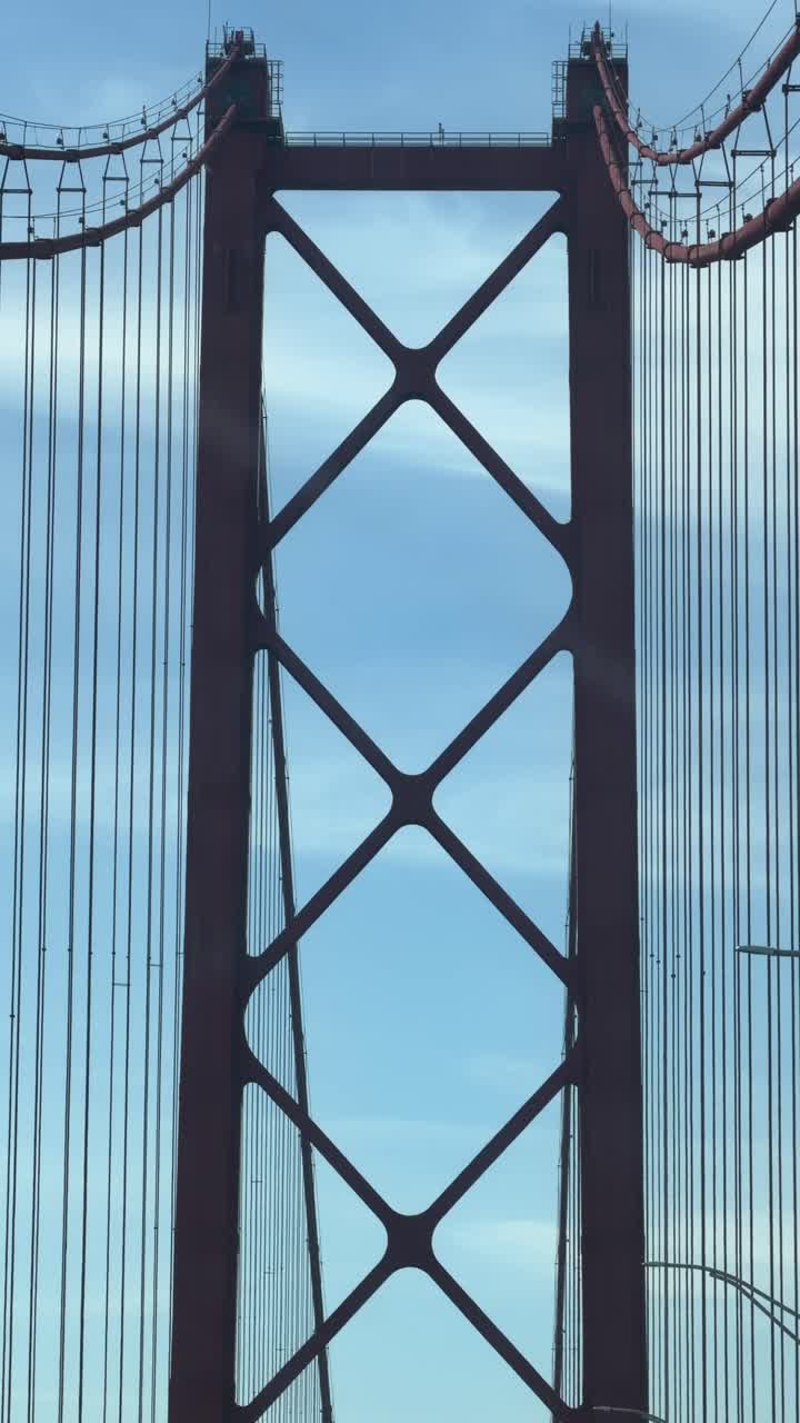 Guidare sotto la torre rossa del ponte sospeso a Lisbona