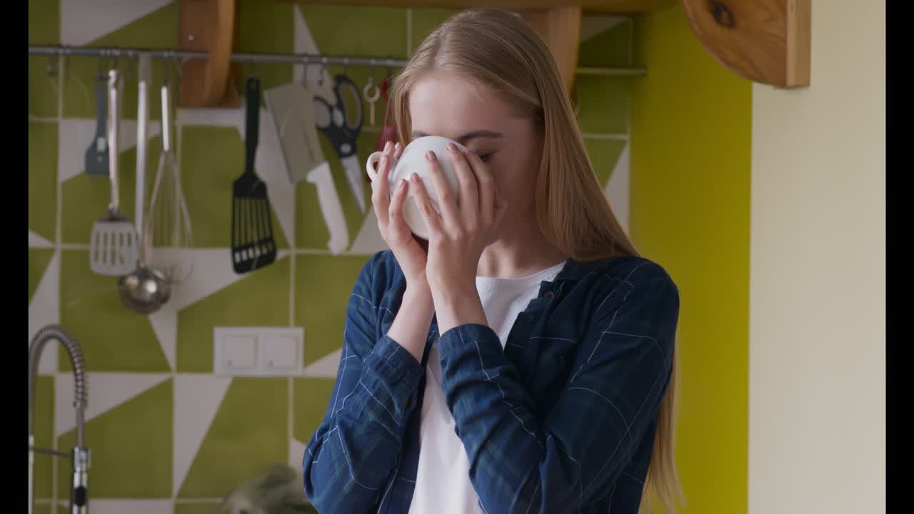 Donna che beve il caffè in cucina