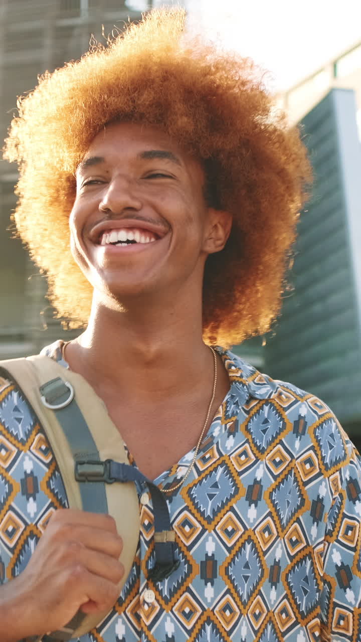Happy Young Man with Curly Hair Smiling in City Sunlight