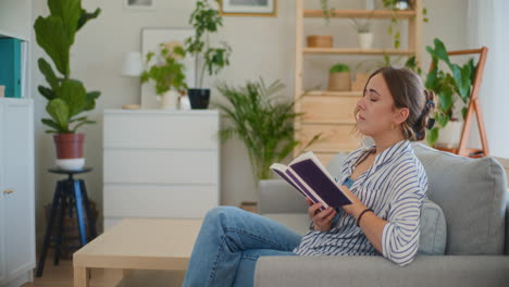 mujer aprendiendo en el sofá leyendo un libro