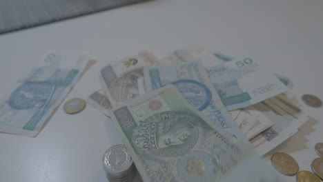 polish zloty paper banknote falling on table with coins