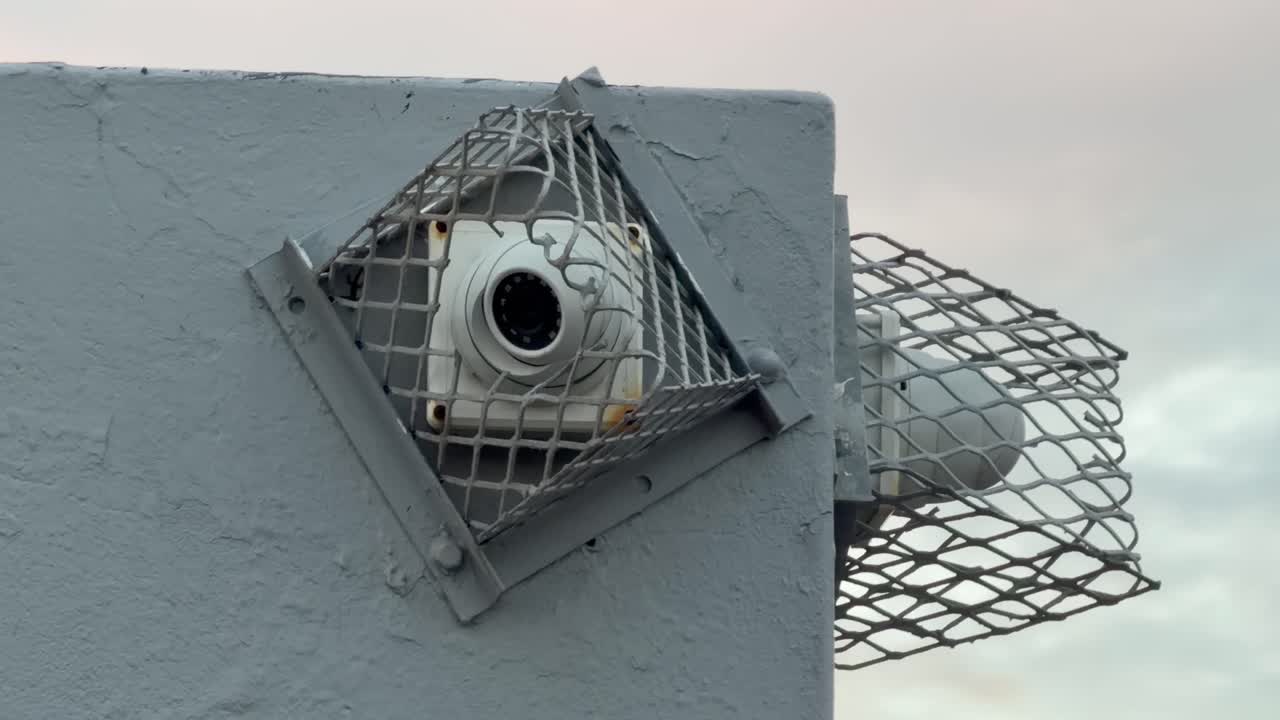 A security camera in a cage hangs to a wall in a suburban part of Cape Town, South Africa
