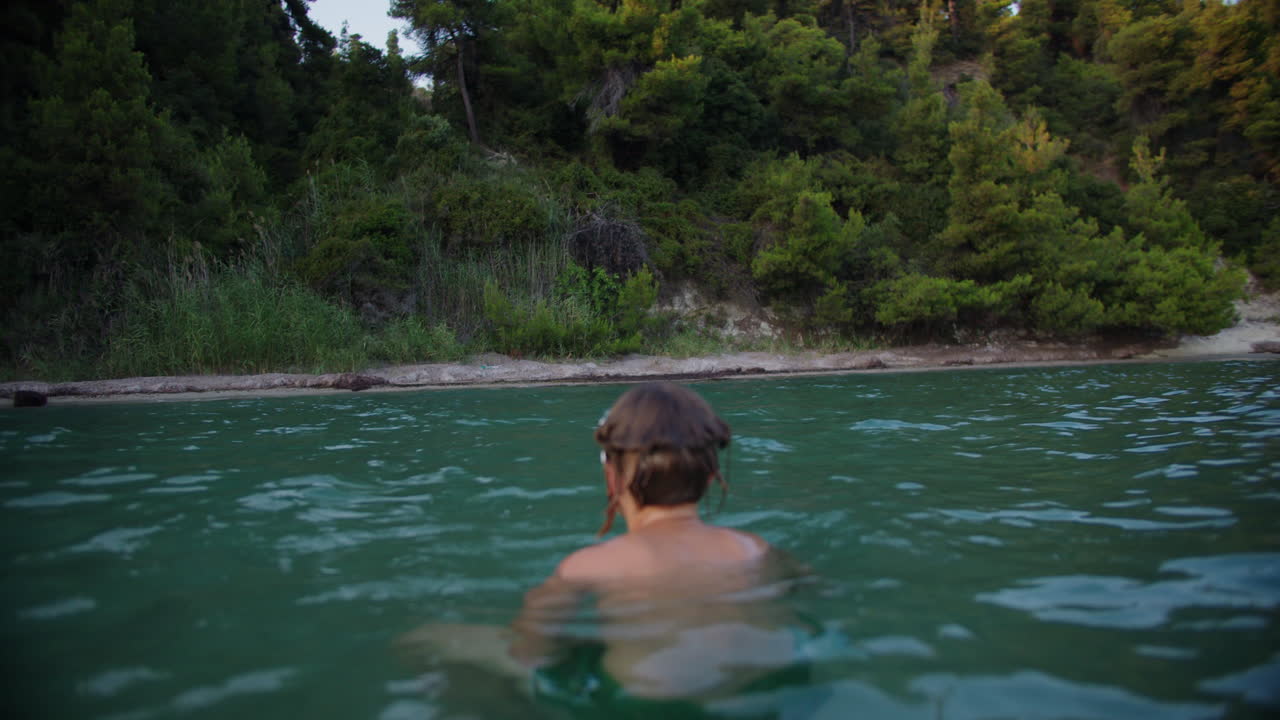 조용 한 호수 에서 수영 하는 사람