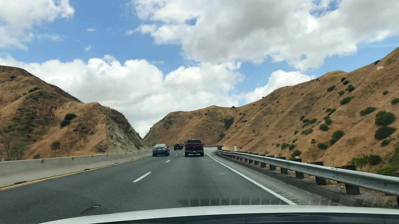 Conduciendo por la autopista a través de montañas en un día soleado y brillante