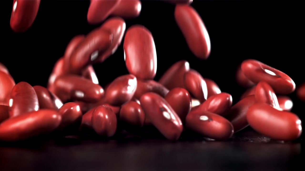 Red Kidney Beans Falling in Slow Motion on a Black Background
