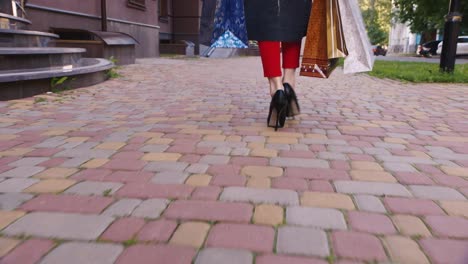 Steadicam-Shot-Woman-With-Shopping-Bags-Walking-On-The-Sidewalk-In-The-Frame-Are-Only-Visible-Legs-F