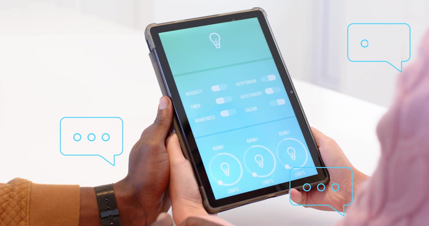 Colleghi posizionano un tablet, discutendo di controlli per l'illuminazione intelligente, con bolle di chat visualizzate sullo schermo.