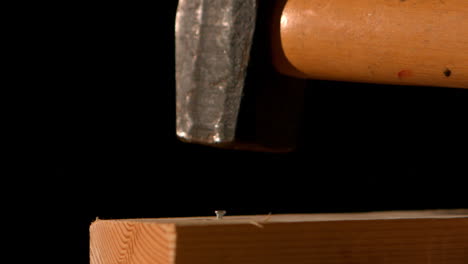 hammer banging a nail into wood