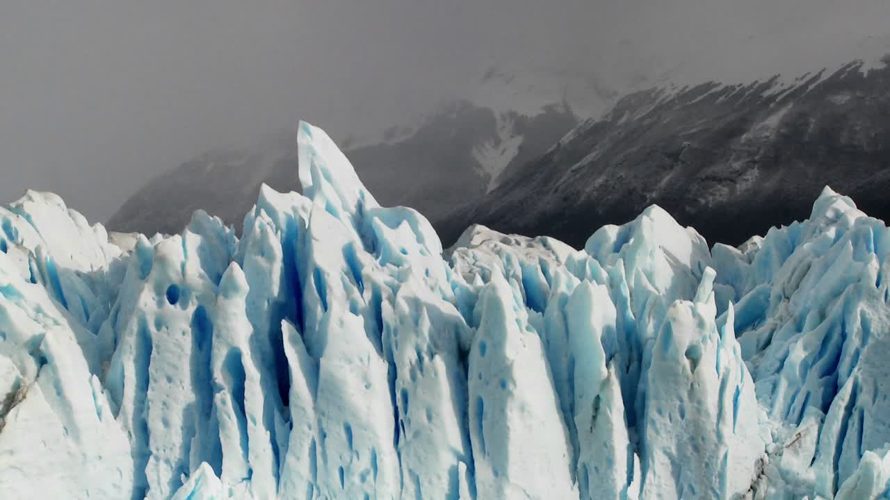 Le cime appuntite di un ghiacciaio si stagliano contro aspre montagne