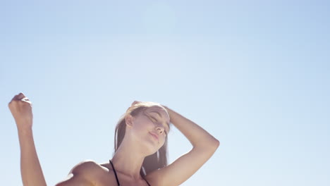 Hermosa-Joven-Atando-El-Cabello-En-Un-Día-Ventoso-En-La-Playa-Tropical-A-Cámara-Lenta