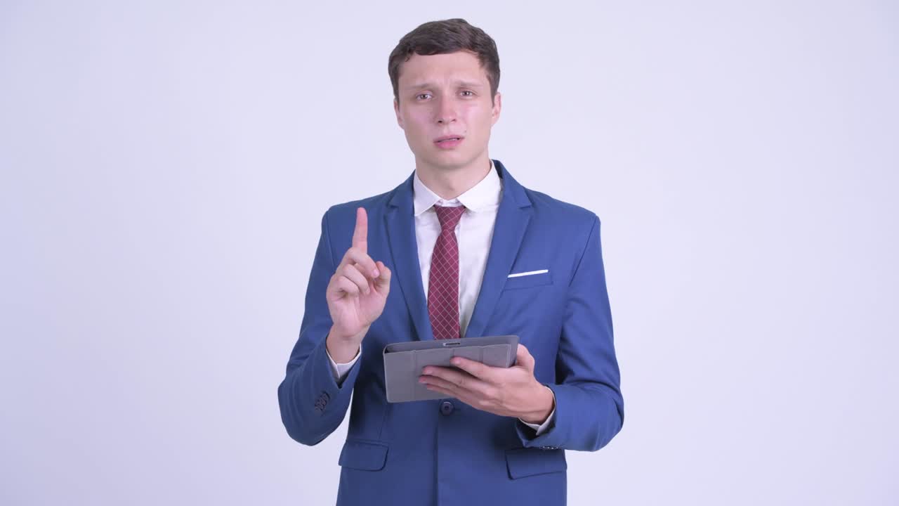 디지털 태블릿을 가진 슈트 입은 젊은 잘생긴 사업가