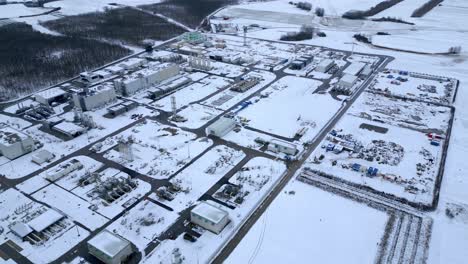 maquinaria pesada y tuberías cubiertas de nieve en la estación compresora de gas natural en invierno