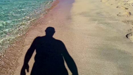 unusual footage of silhouette shadow of man walking on sandy beach seaside turquoise sea water