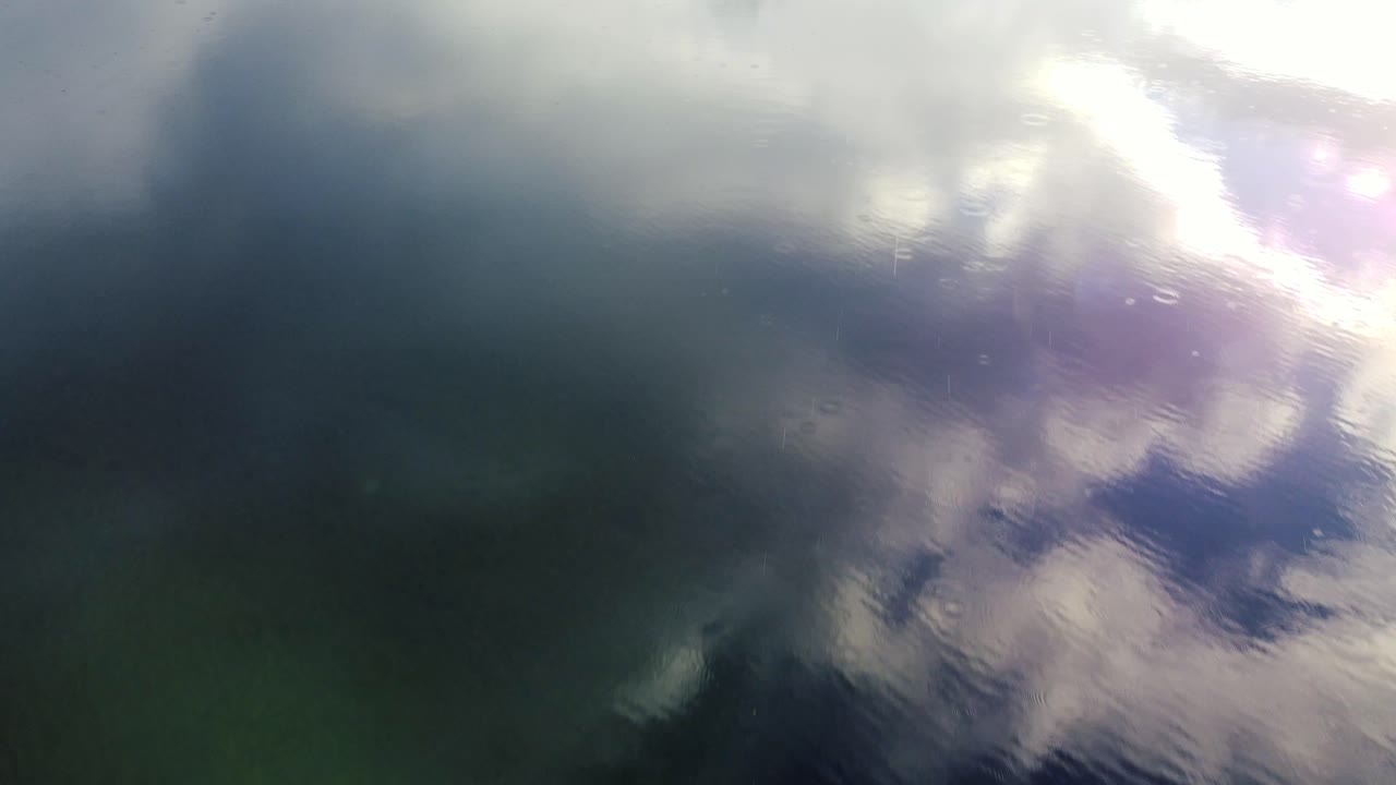 Stunning rainy lake drone flyover with clouds in the reflection in beautiful BC
