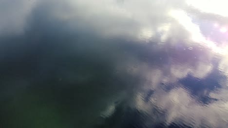 stunning rainy lake drone flyover with clouds in the reflection in beautiful bc