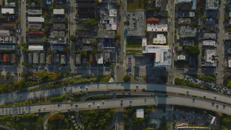 busy multilane highway and buildings in residential neighbourhoods around. top down footage at golden hour. miami, usa