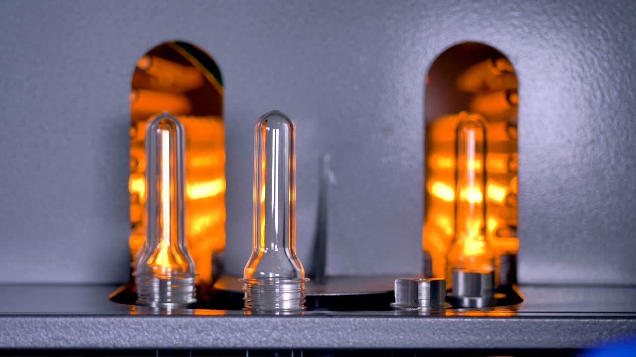 el trabajador opera una línea de preformas de plástico a alta velocidad.