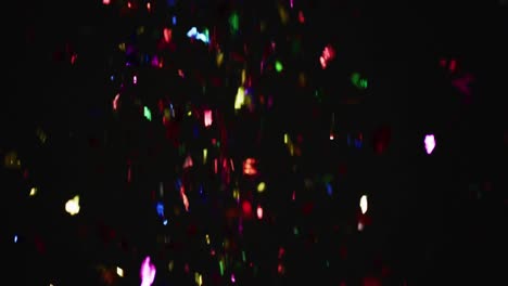 Multicoloured-confetti-falling-on-black-background