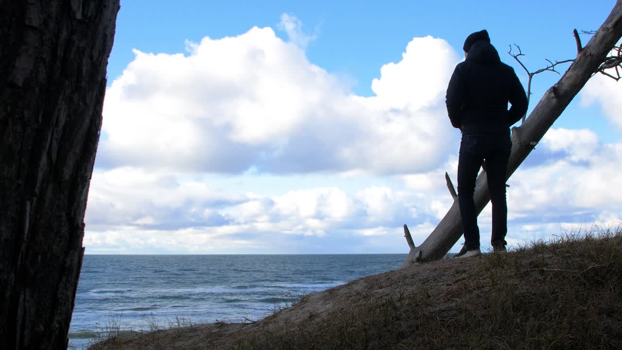 북유럽 해변 숲을 탐험하는 백인 남성, 발트해 해변 근처의 해안 소나무 숲에서 혼자 걷는 남자, 구름과 함께 화창한 날, 건강한 활동 개념, 중간 샷