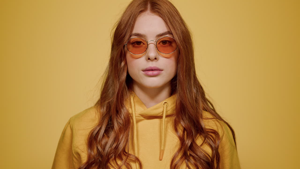 스튜디오에서 포즈를 취하는 홍색 머리 여성의 초상화. 실내 렌즈를 쳐다보는 소녀