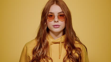 portrait of ginger hair woman posing in studio. girl staring at lens indoors