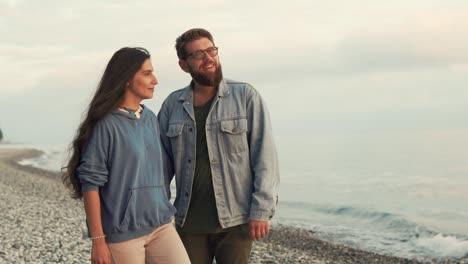 una pareja en la playa al atardecer.