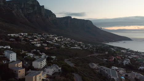 aerial showing cars driving in camps bay in the evening after sunset in cape town, south africa