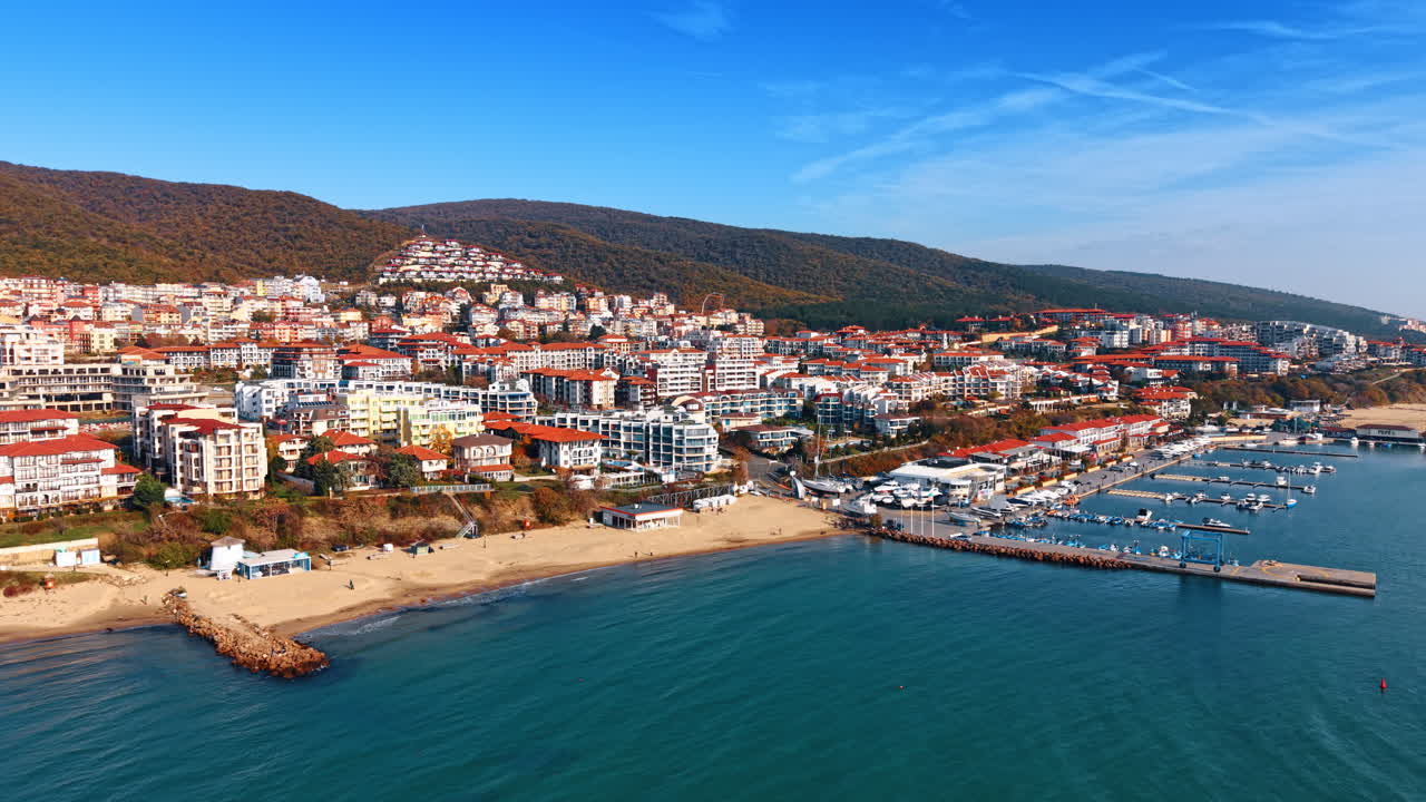 Vista aerea di una spiaggia e dell'architettura di un resort costiero. Prospettiva dall'alto di una spiaggia sabbiosa, acqua turchese e fitti edifici residenziali.
