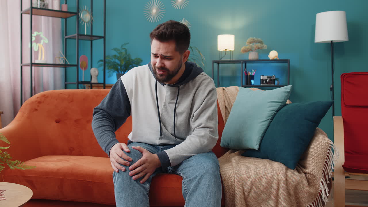 Young caucasian man suffer from painful severe knee joint ache leg muscles illness cramps rheumatism