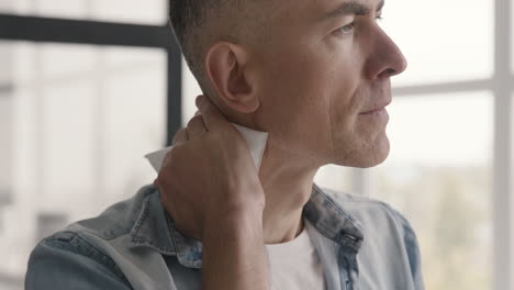 hombre de mediana edad tratando de calmar el dolor cervical usando una bolsa de hielo