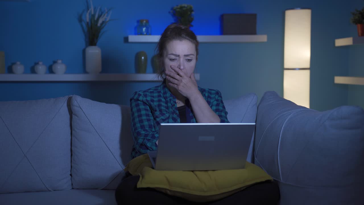 밤에 노트북에서 영화를 보는 여자.