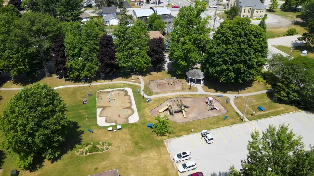 disparo aéreo dando vueltas sobre un parque y un patio de recreo en un día soleado en mount bridges