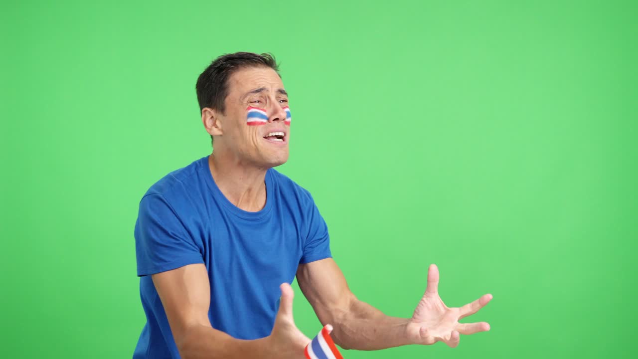 Nervous man cheering for Thailand during a match looking away