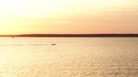 golden light reflecting on quiet water near harbor pier with distant soft horizon edge