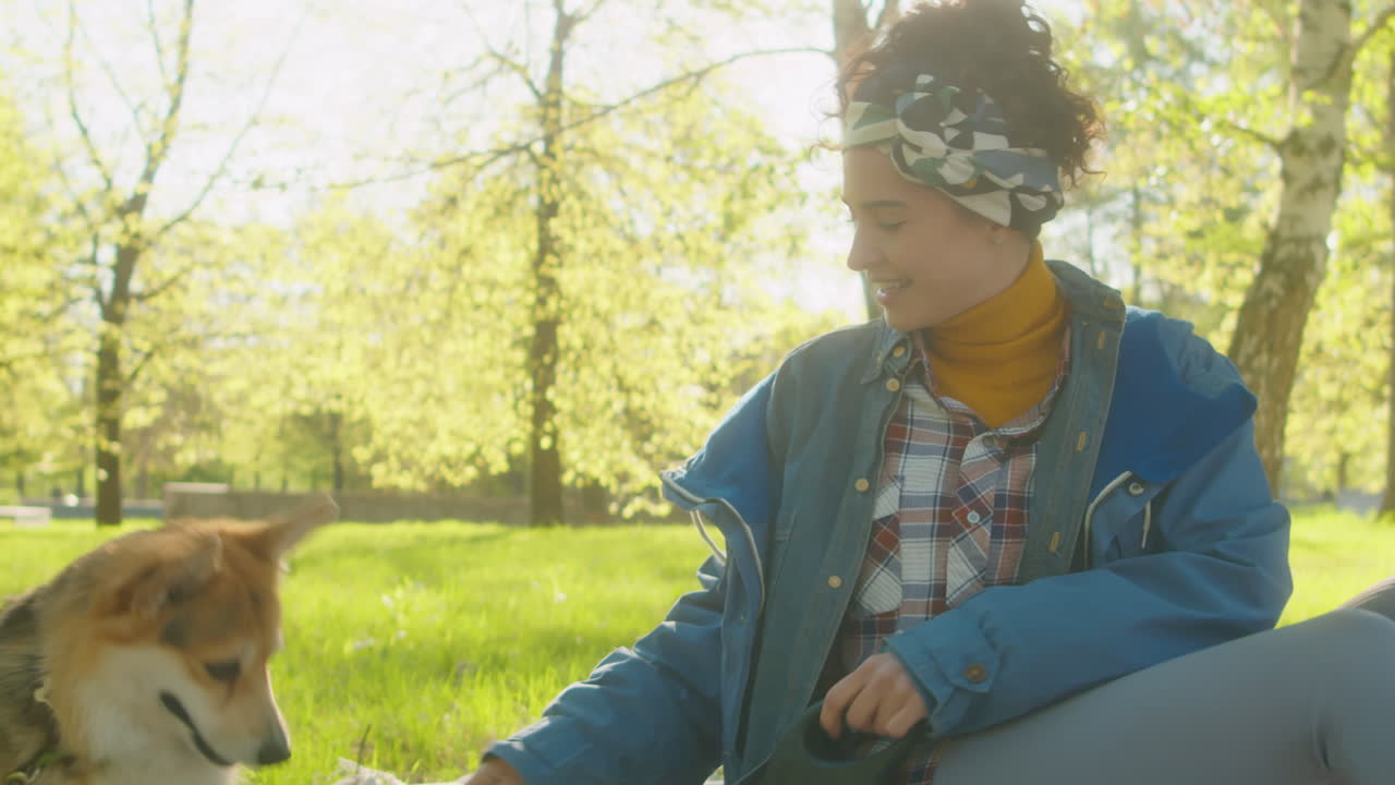 Woman Plays with Her Dog in a Sunny Park