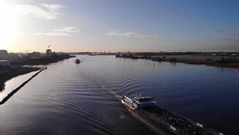 barcaza cisterna viaja por el plácido río de oude maas durante el amanecer en el sur de holanda, países bajos