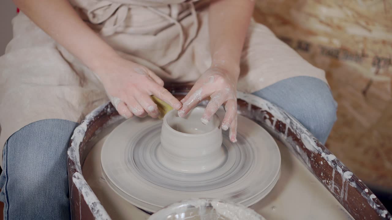mujer formando un cuenco de cerámica en una rueda de cerámica