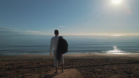 Hombre-Parado-En-La-Playa,-Con-Un-Pequeño-Movimiento-De-Cámara