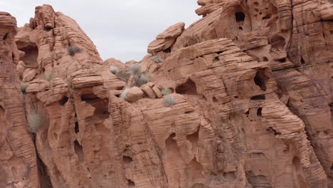 Red-sandstone-rock-formation-in-Nevada,-revealing-the-Valley-of-Fire-in-the-back